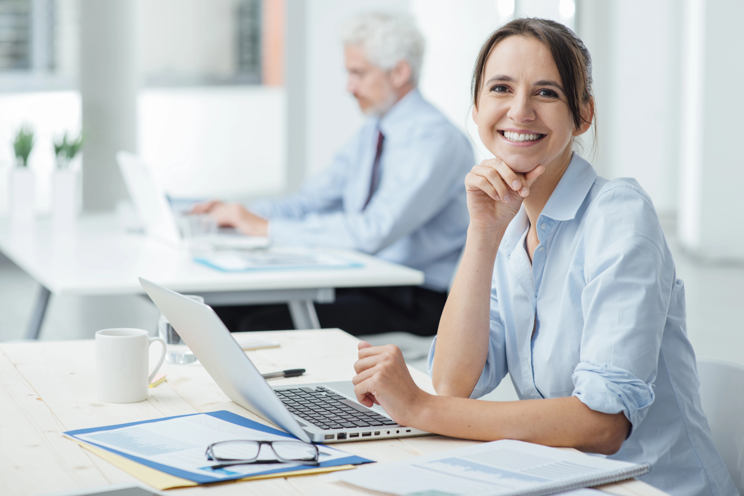 Smiling women at desk looking a t camera