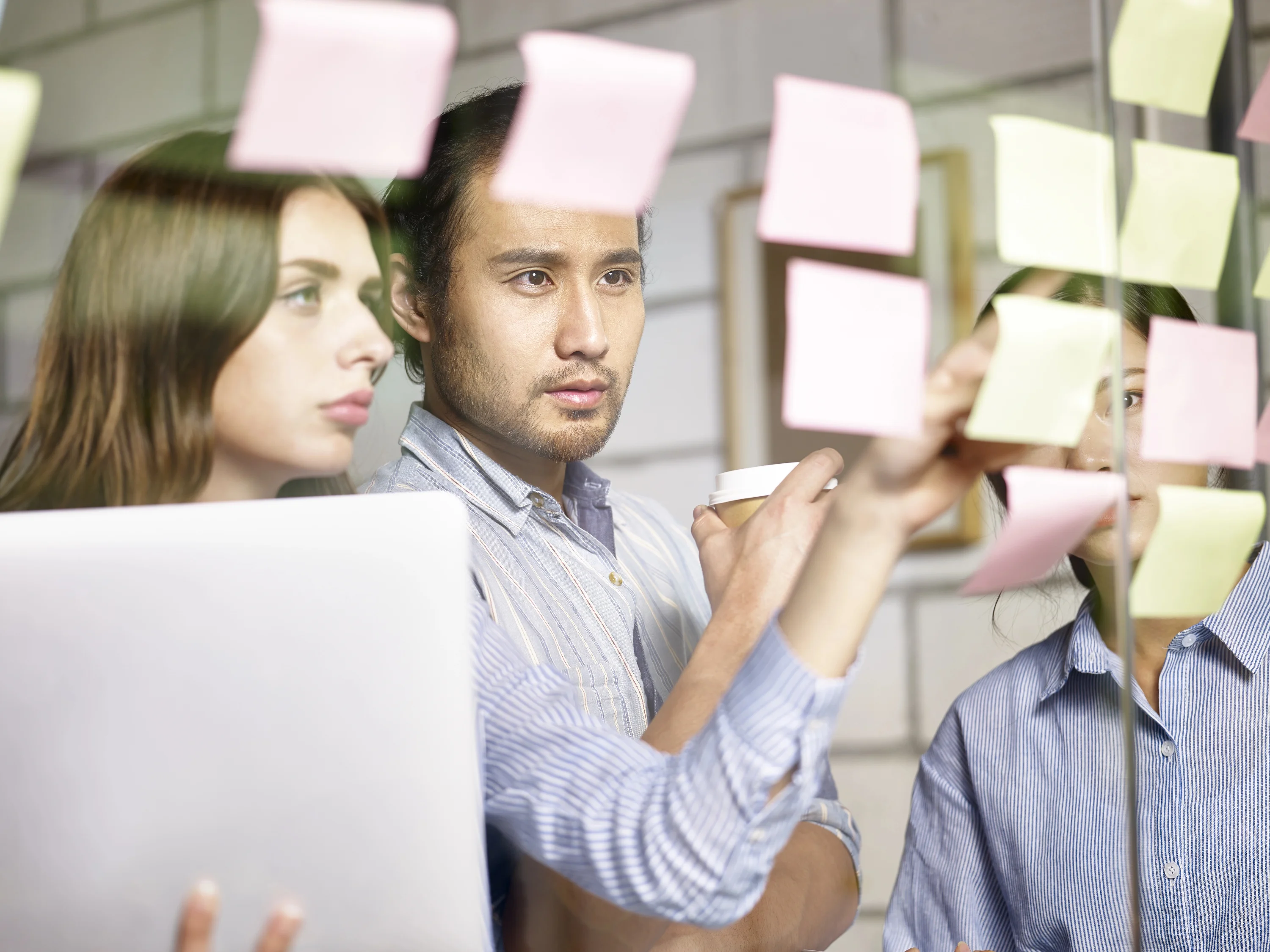 Two office workers looking at a whiteboard with post it notes